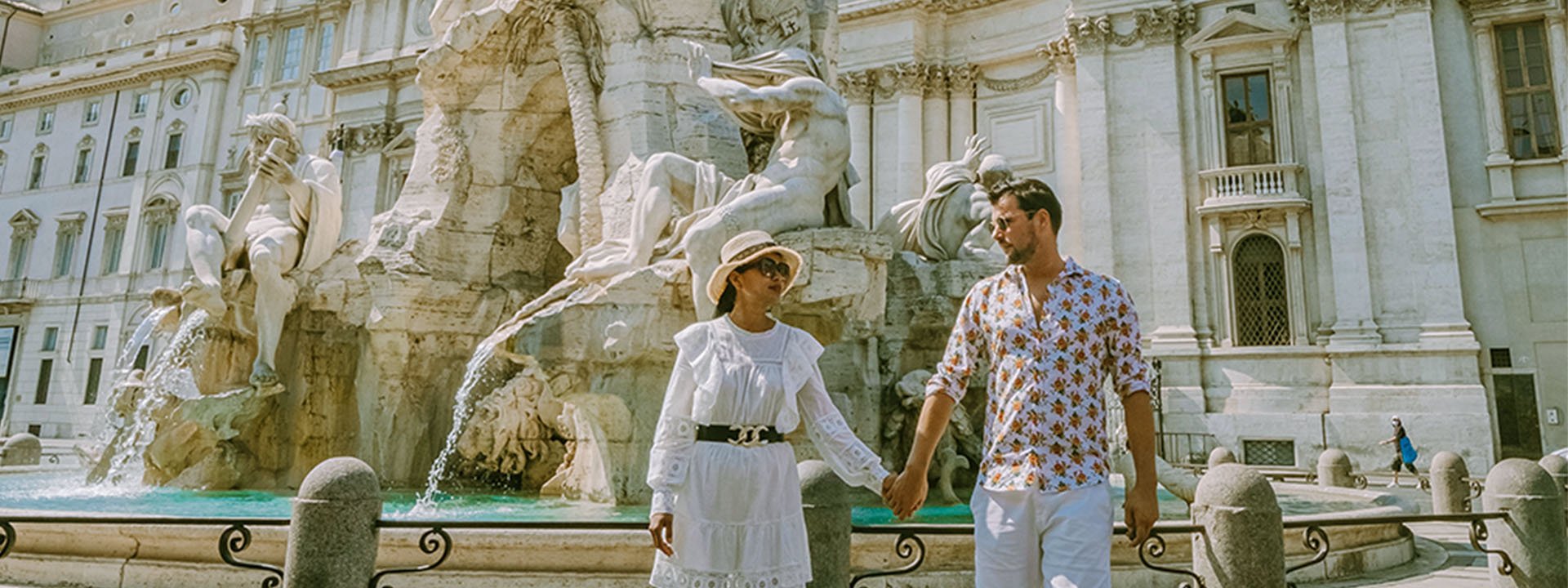 People holding hands, with a fountain in the background