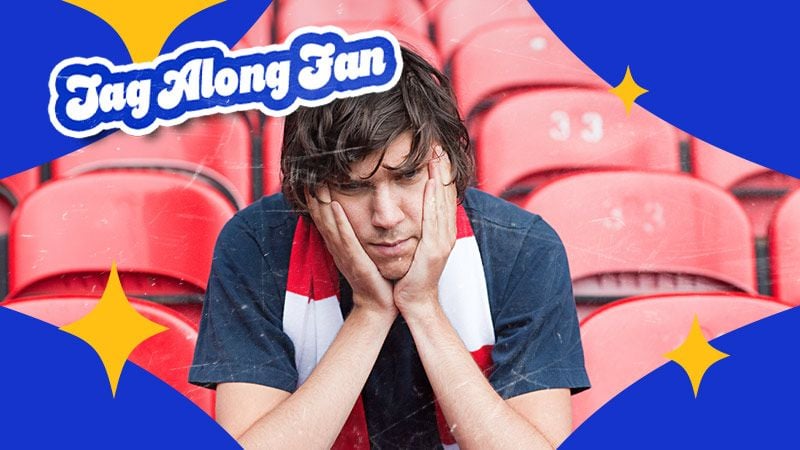 A person in a football stadium, looking despondent with head in hands, wearing a red and white scarf. Blue frame and "Tag Along Fan" text add emphasis.