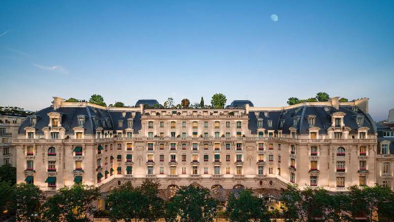 Grand historic hotel facade at dusk under a clear evening sky