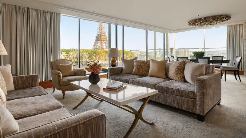 Spacious luxury suite living room with floor-to-ceiling windows and Eiffel Tower view