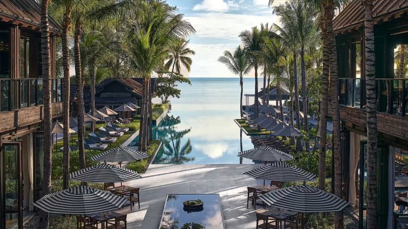 Tropical beachfront resort with palm trees, infinity pool, and ocean view