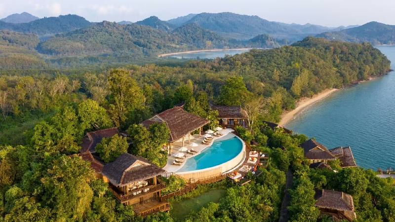 Aerial view of a luxury hillside resort with pool overlooking the coastline