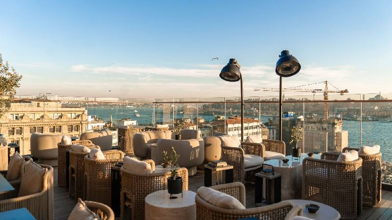 Rooftop terrace with comfortable lounge seating and sweeping waterfront city views