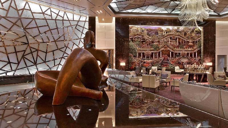 Modern luxury hotel lobby with abstract sculpture, dramatic lighting, and stylish seating area