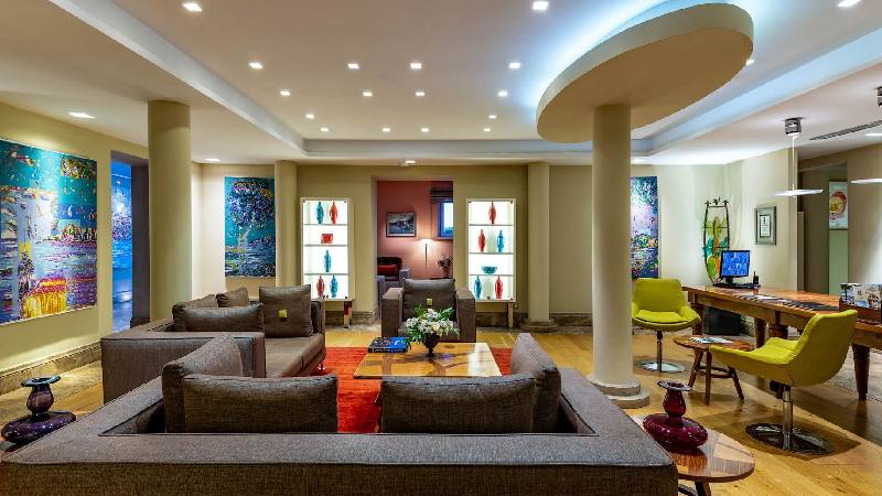 Contemporary hotel lounge with cozy seating, colorful artwork, and warm ambient lighting